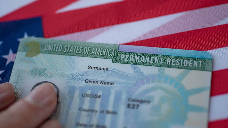 Permanent Resident Green card of United states of America on flag of USA.